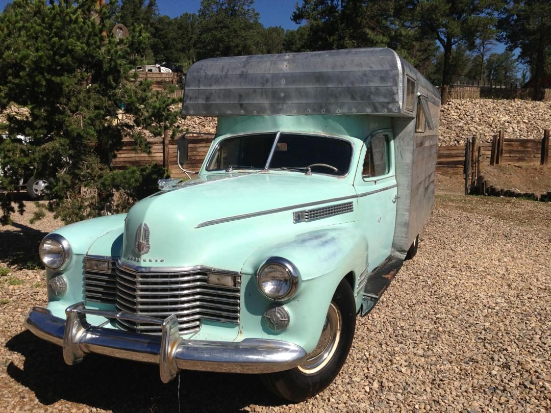 A mint green vintage camper truck parked at the resort